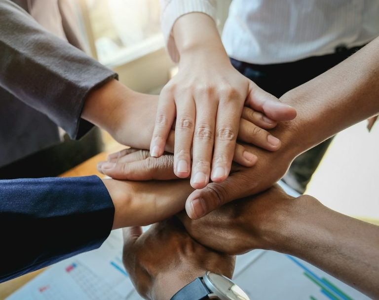 Several hands stacked together, symbolising teamwork and unity.